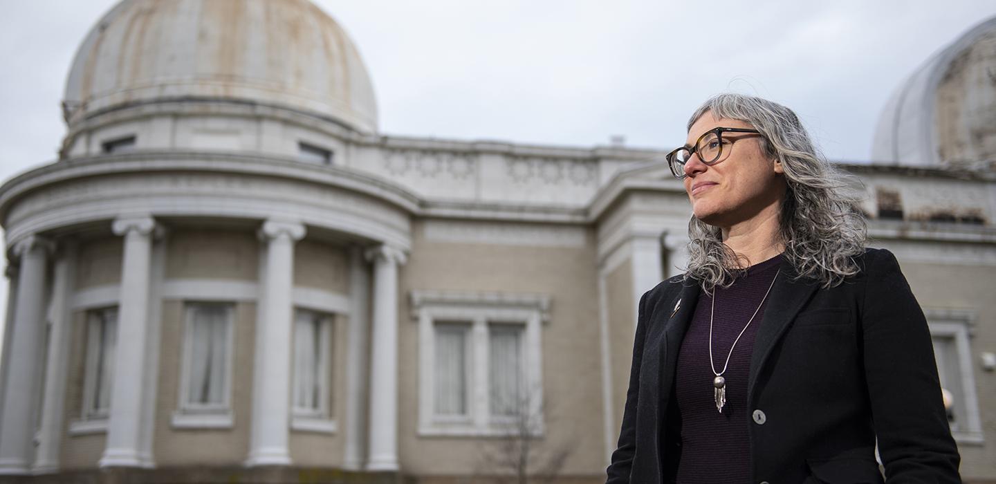 Rachel Bezanson looking to the side, standing in front of building
