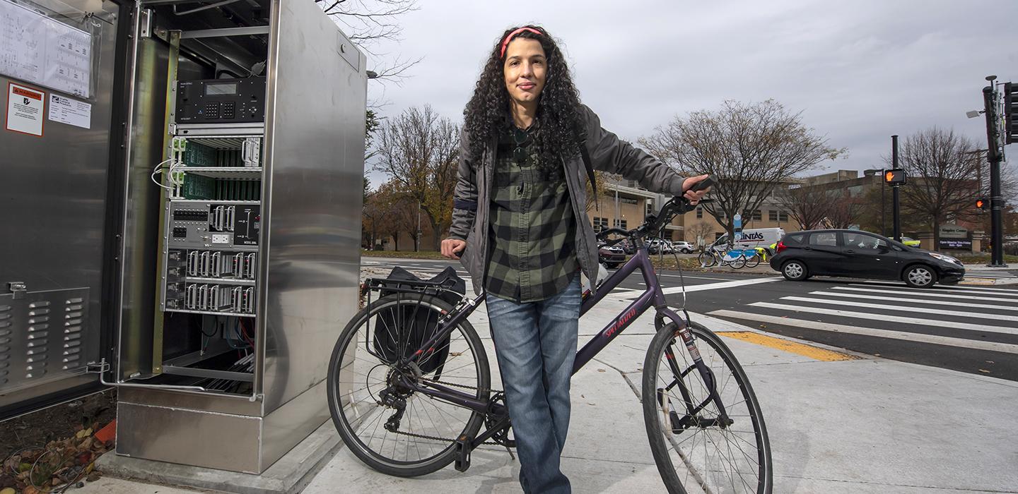 Mateus Martins standing with bicycle on the sidewalk.