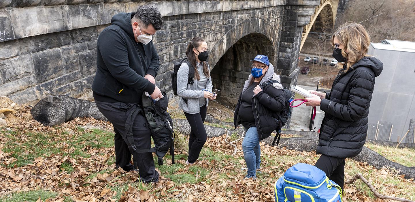 Street Medicine workers helping the homeless near a bridge