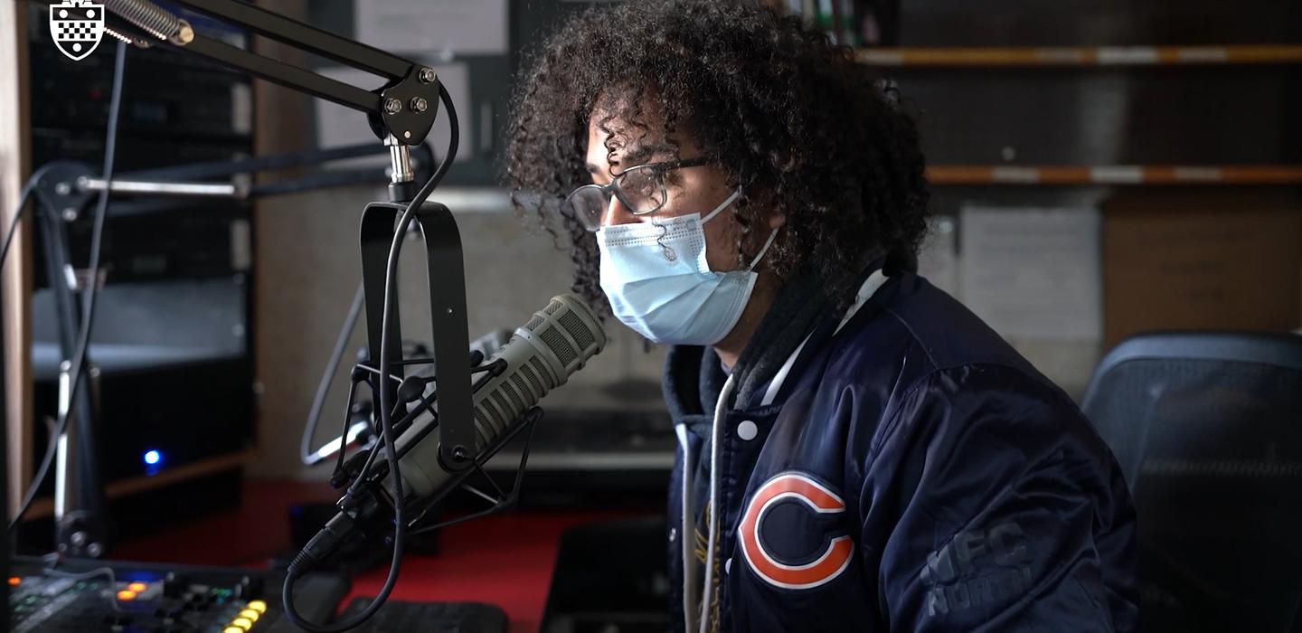 Alex Randall speaking into microphone in broadcasting studio