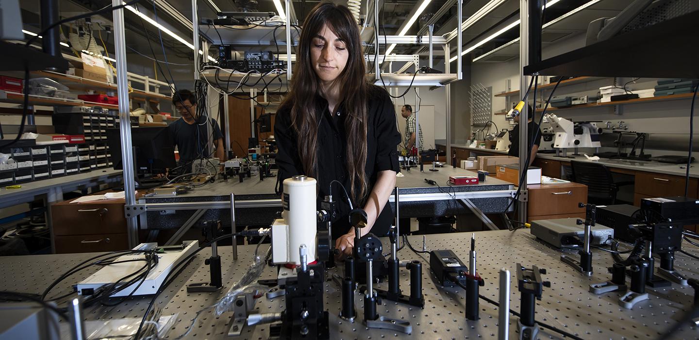 a woman working at a table filled with thermophysics equipment