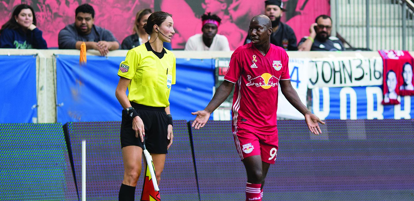 Kathryn Nesbitt talking to soccer player on the field