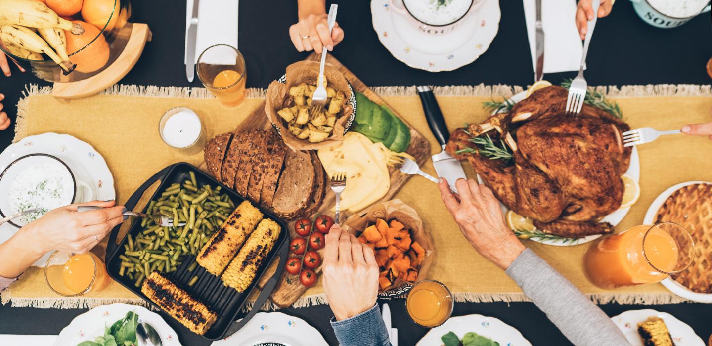 People grabbing food from table during a feast