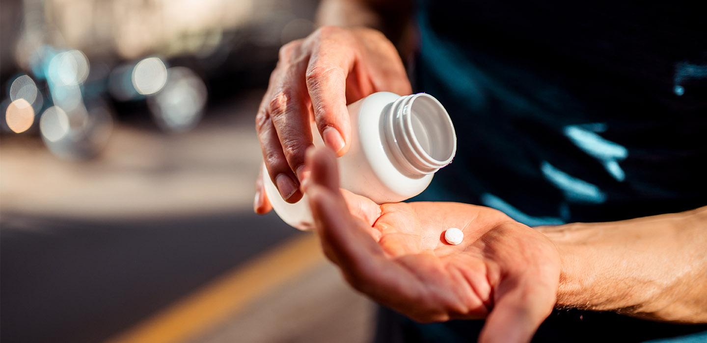 pouring a pill out of a bottle