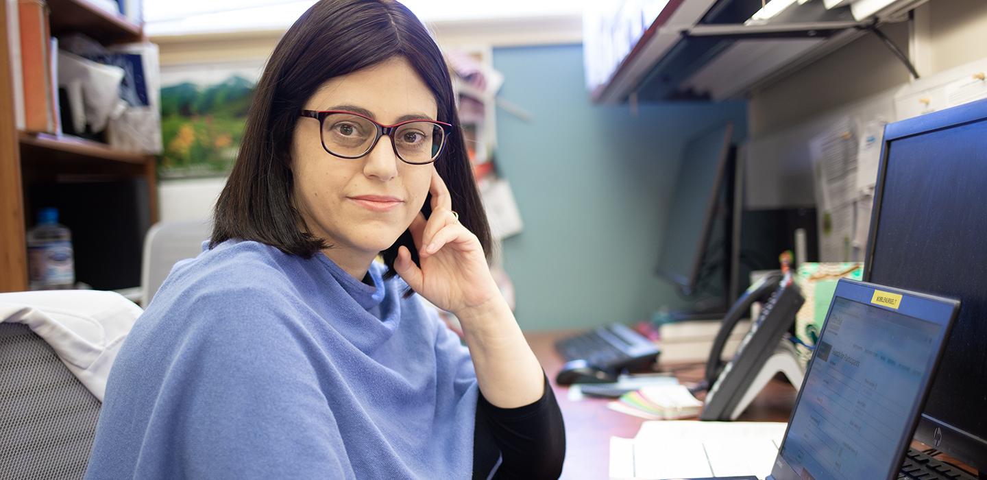 Mylynda Massart sitting at desk in office