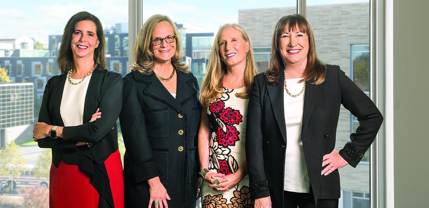 The four authors of "The No Club" standing together in front of large window