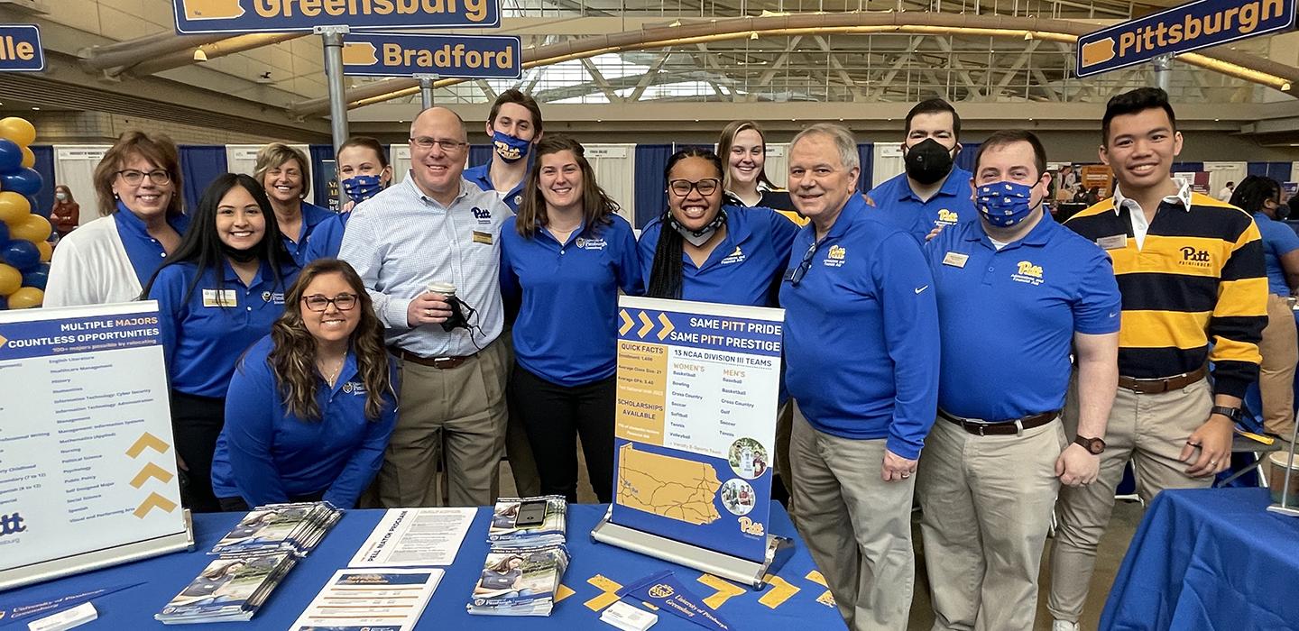 Pitt people standing together behind table