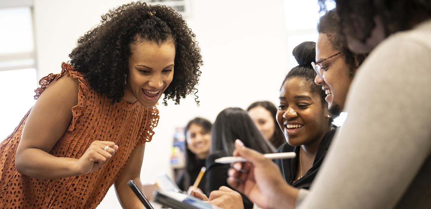an instructor interacting with students holding a tablet