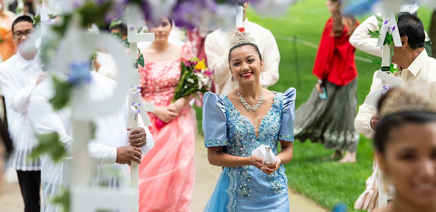 A person in a traditional Philippine dress walks in a procession