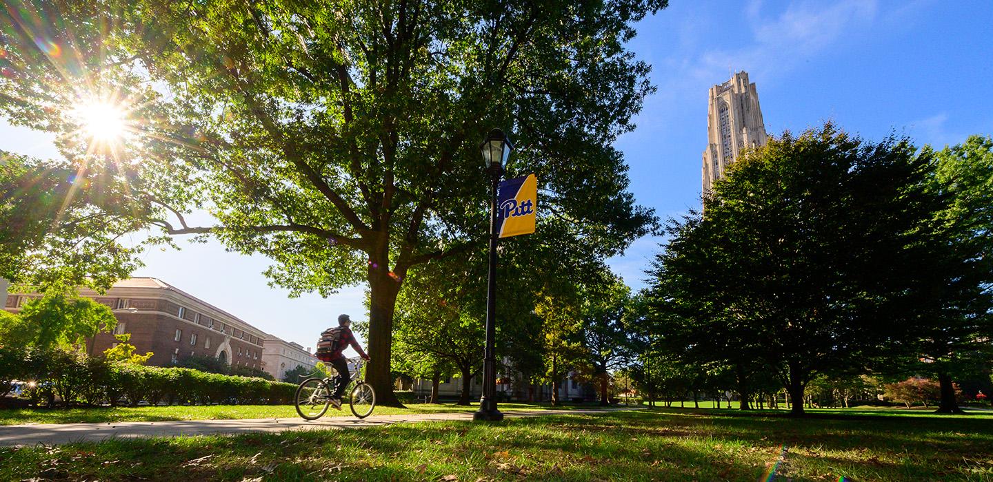 A person bikes on Pitt's campus
