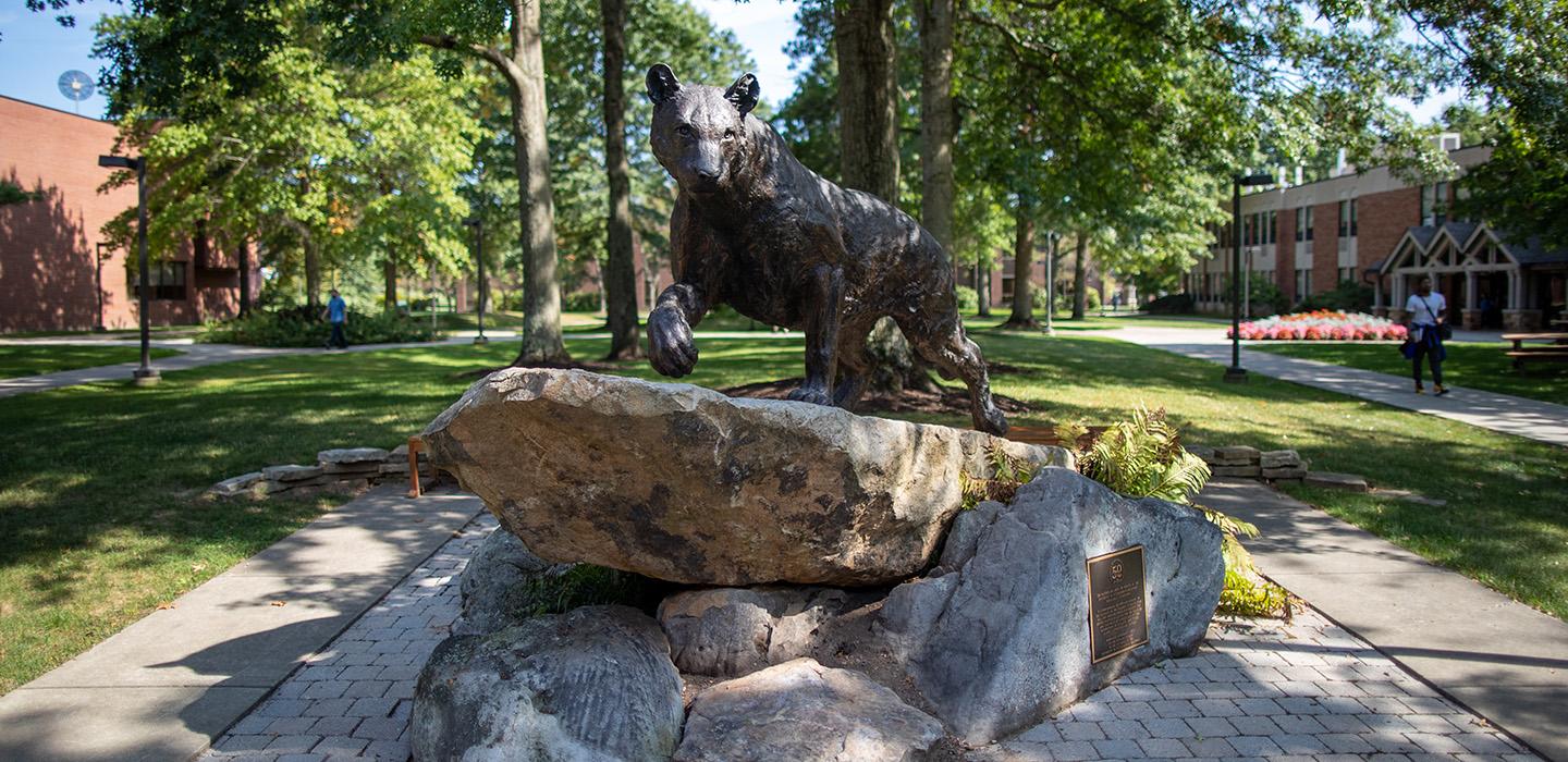 A bobcat statue atop a rock