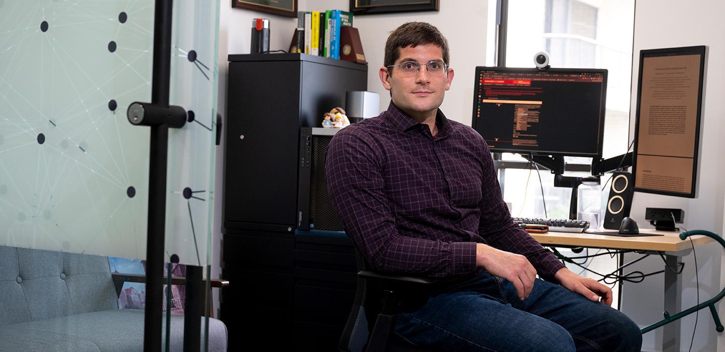 Morgan Frank sits at his office desk