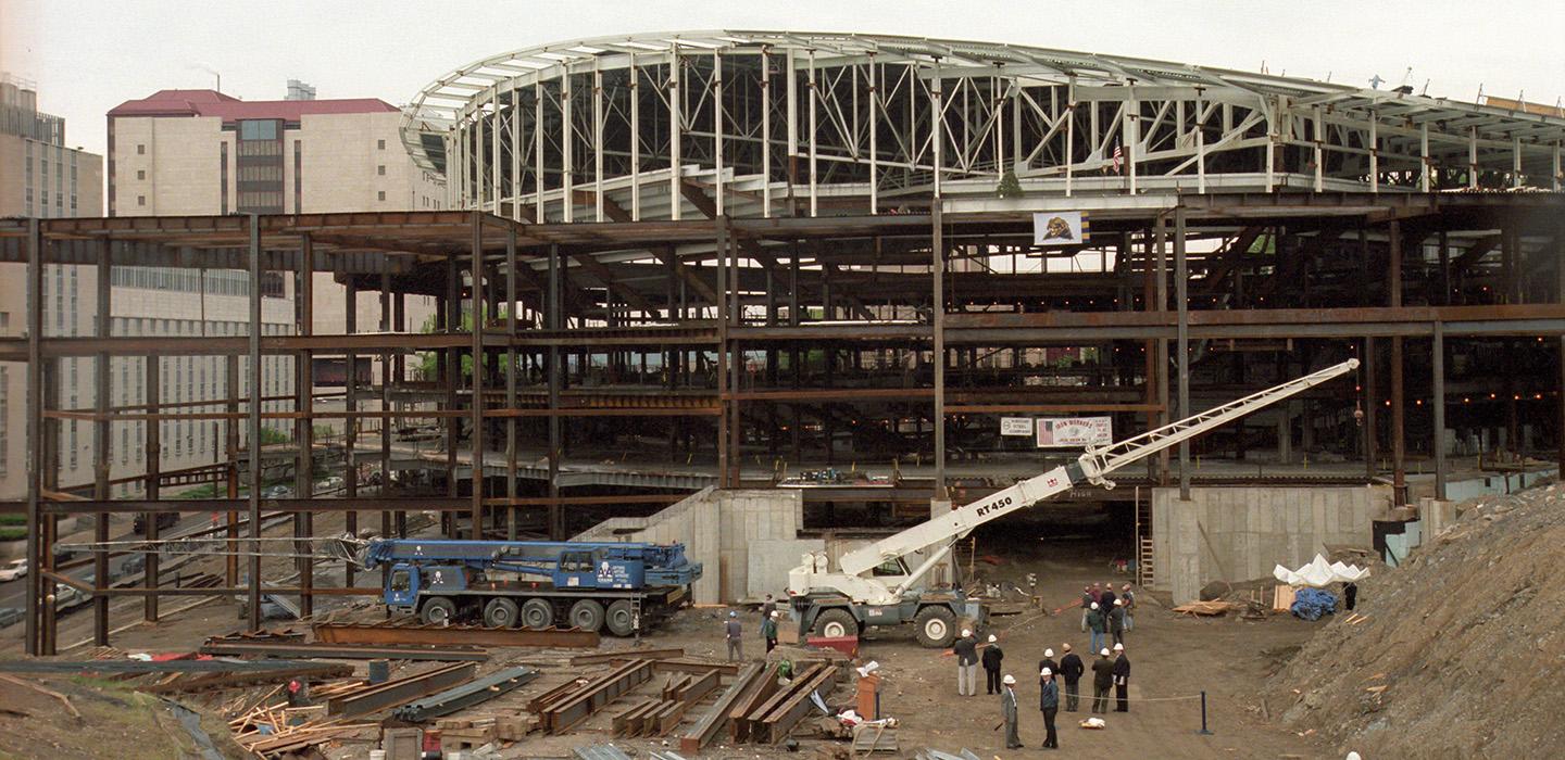 A crane lifts beams during construction of the Petersen Events Center