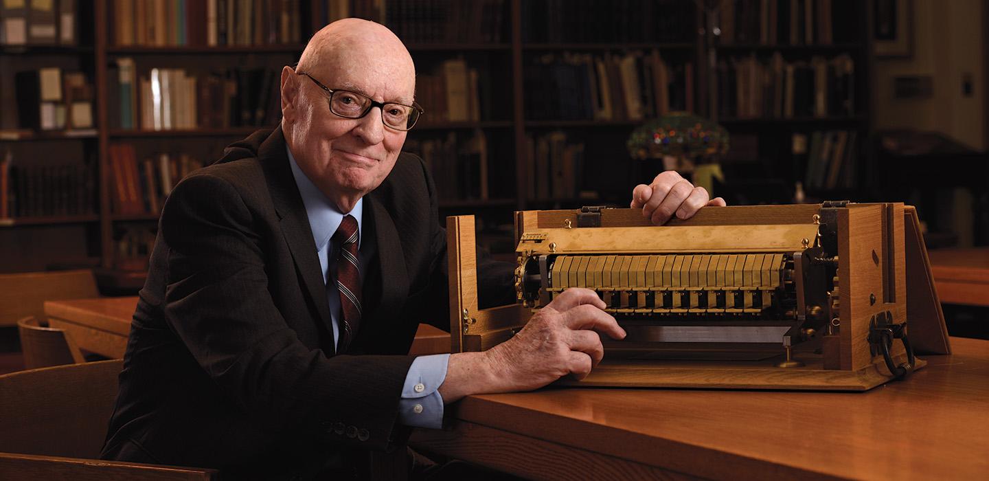 Rescher sits next to a gold cypher machine