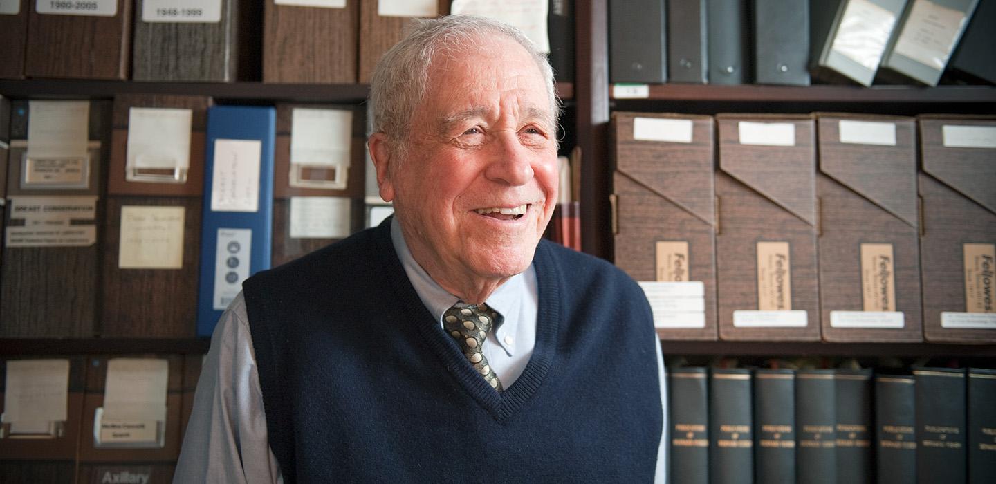 Fisher in front of a shelf of files and books