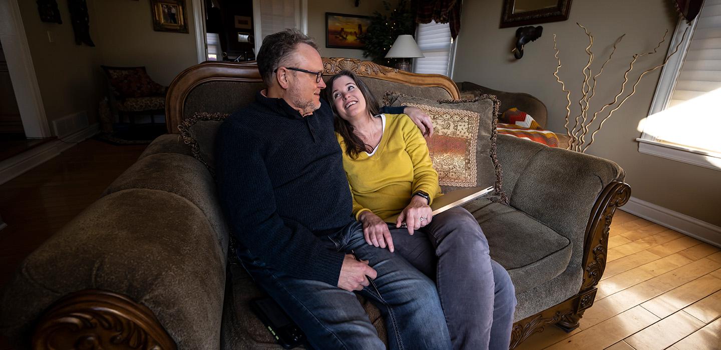 The Vorps sit on a couch in their home