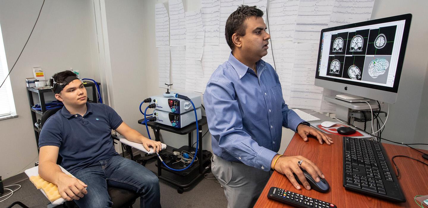 A subject and professor look at brain scans on a monitor