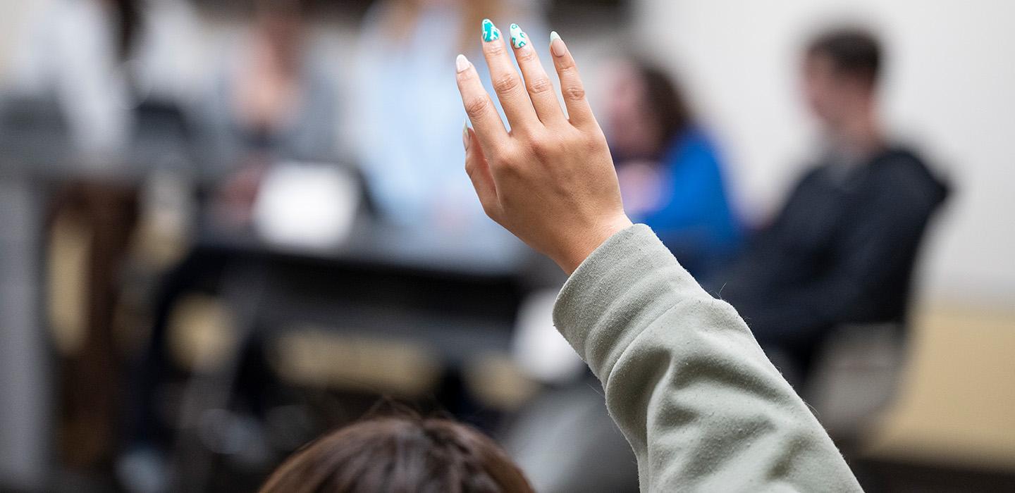 A raised hand in a classroom