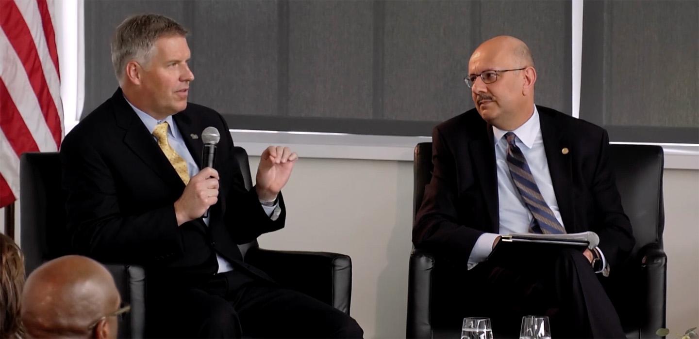 Chancellor Gallagher talks into a microphone during a panel