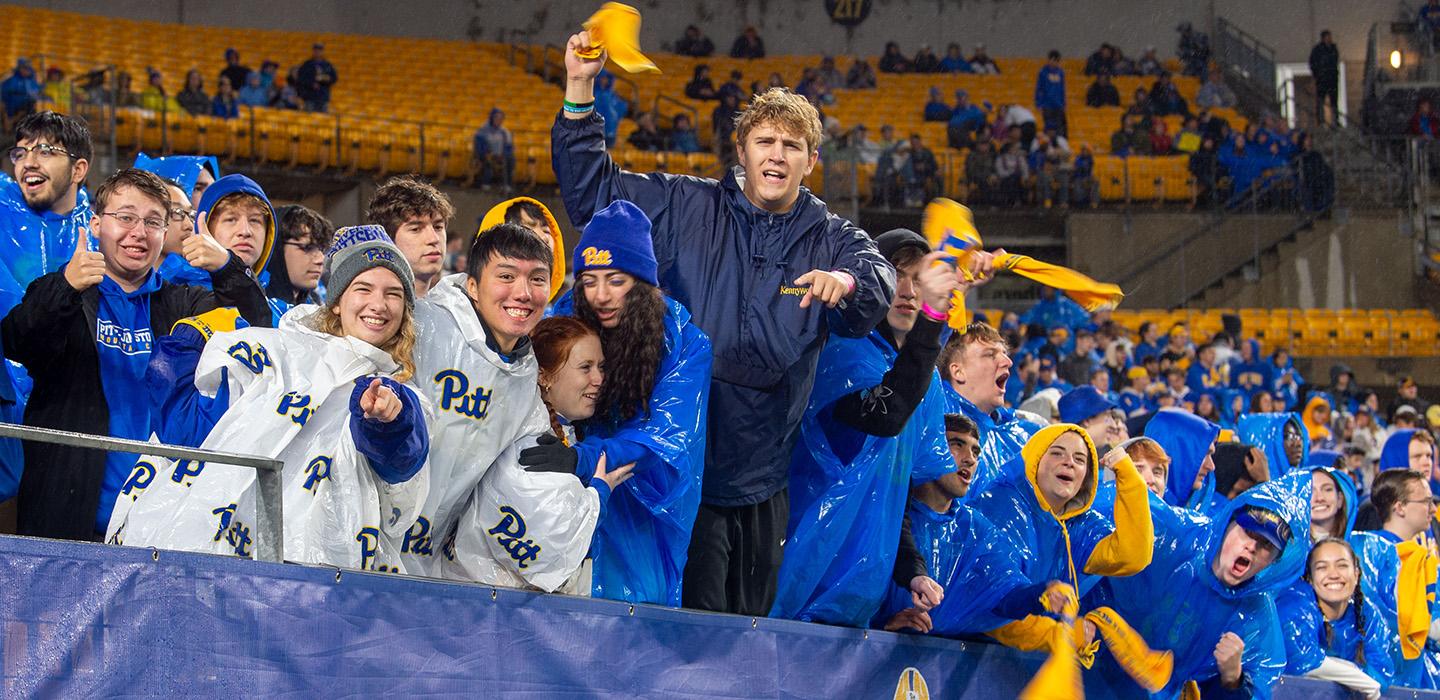 Students in Pitt gear cheer in stadium stands