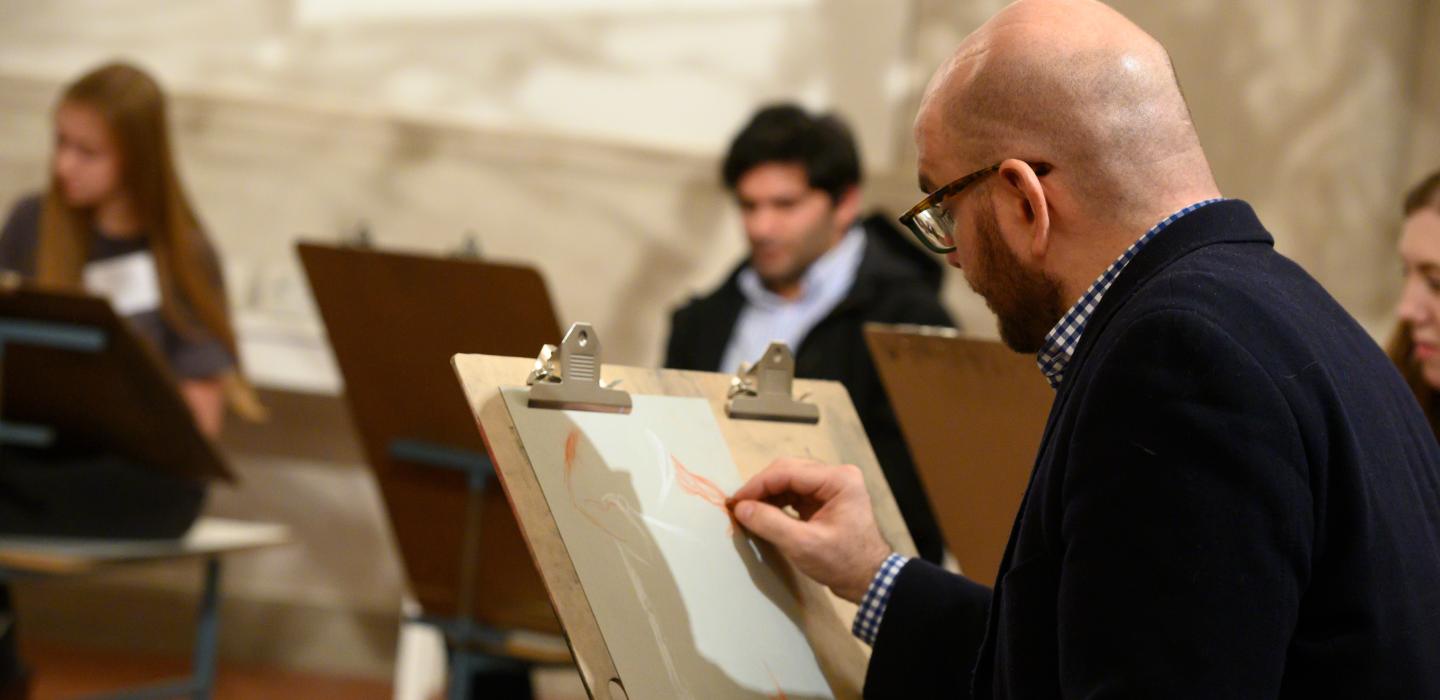 An individual draws during a University Art Gallery Maker Event.