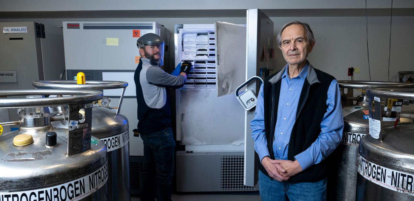 Charles Rinaldo poses for a portrait in the lab with a colleague.