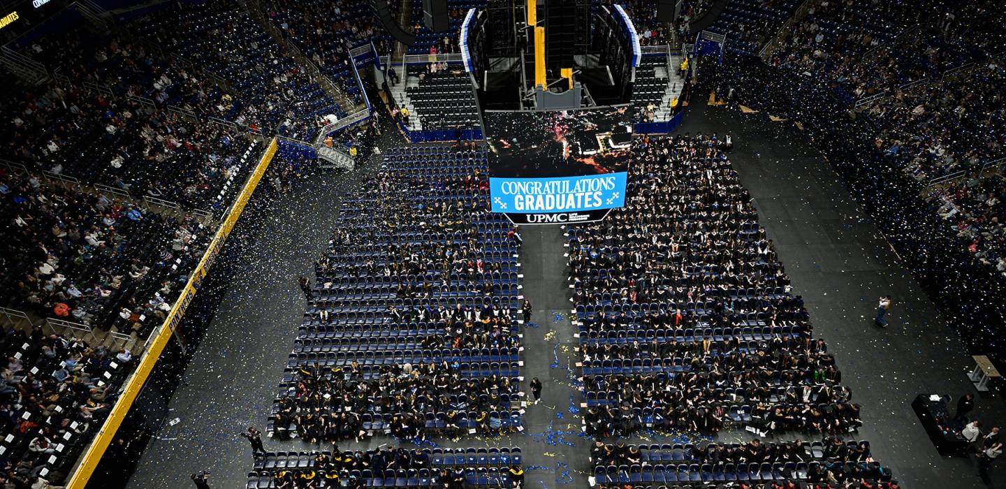 Confetti falls over winter commencement graduates and attendees.