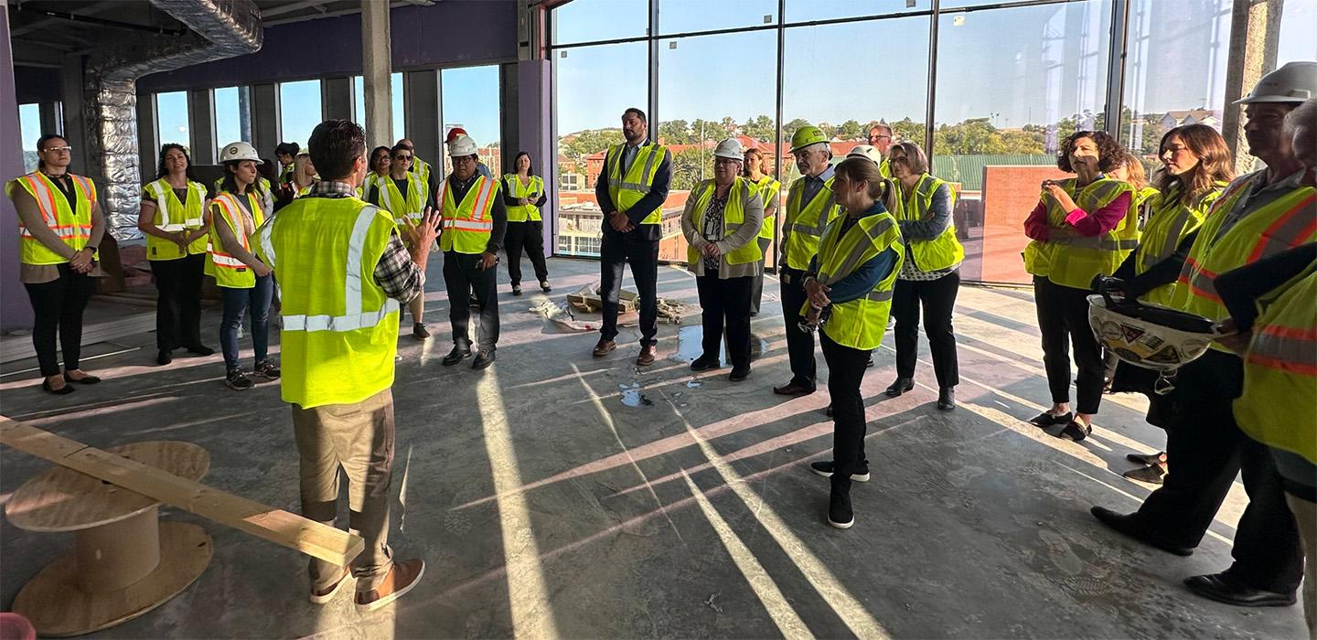 People in yellow vests tour a construction site