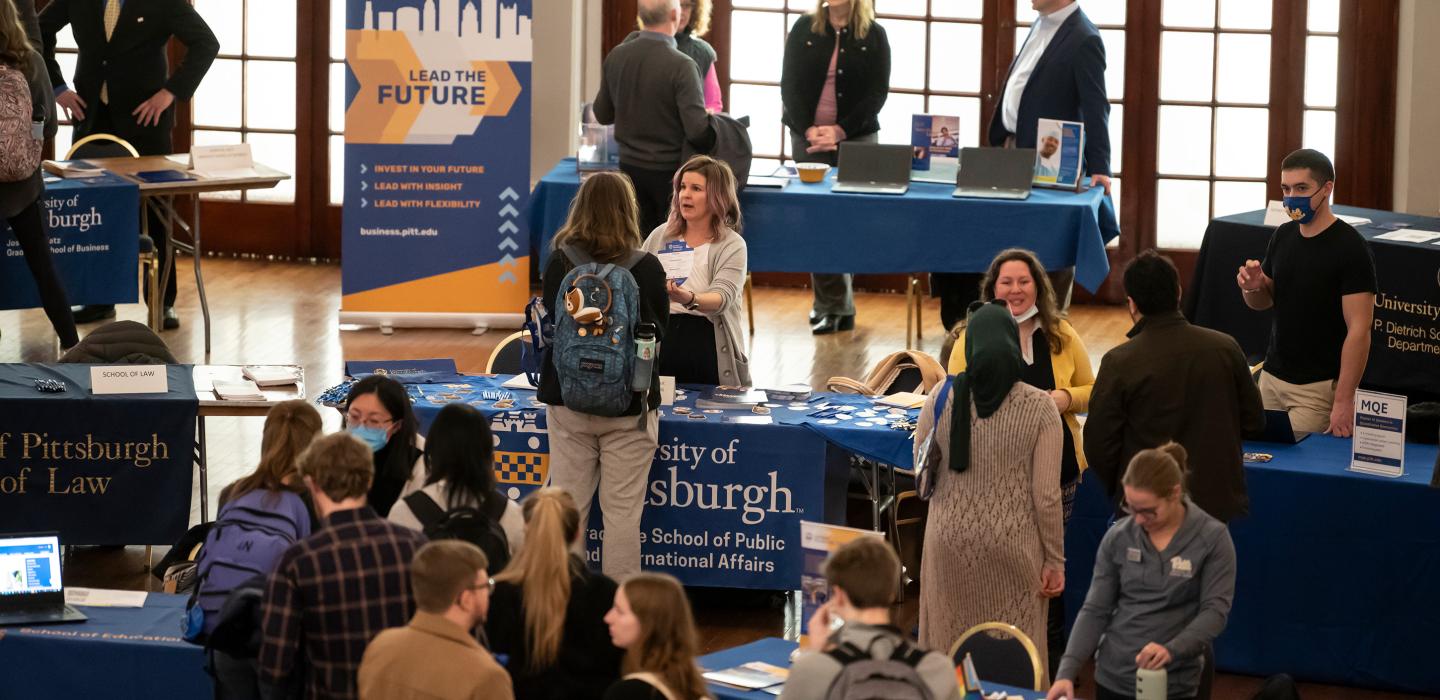 People gather at tables during an information fair