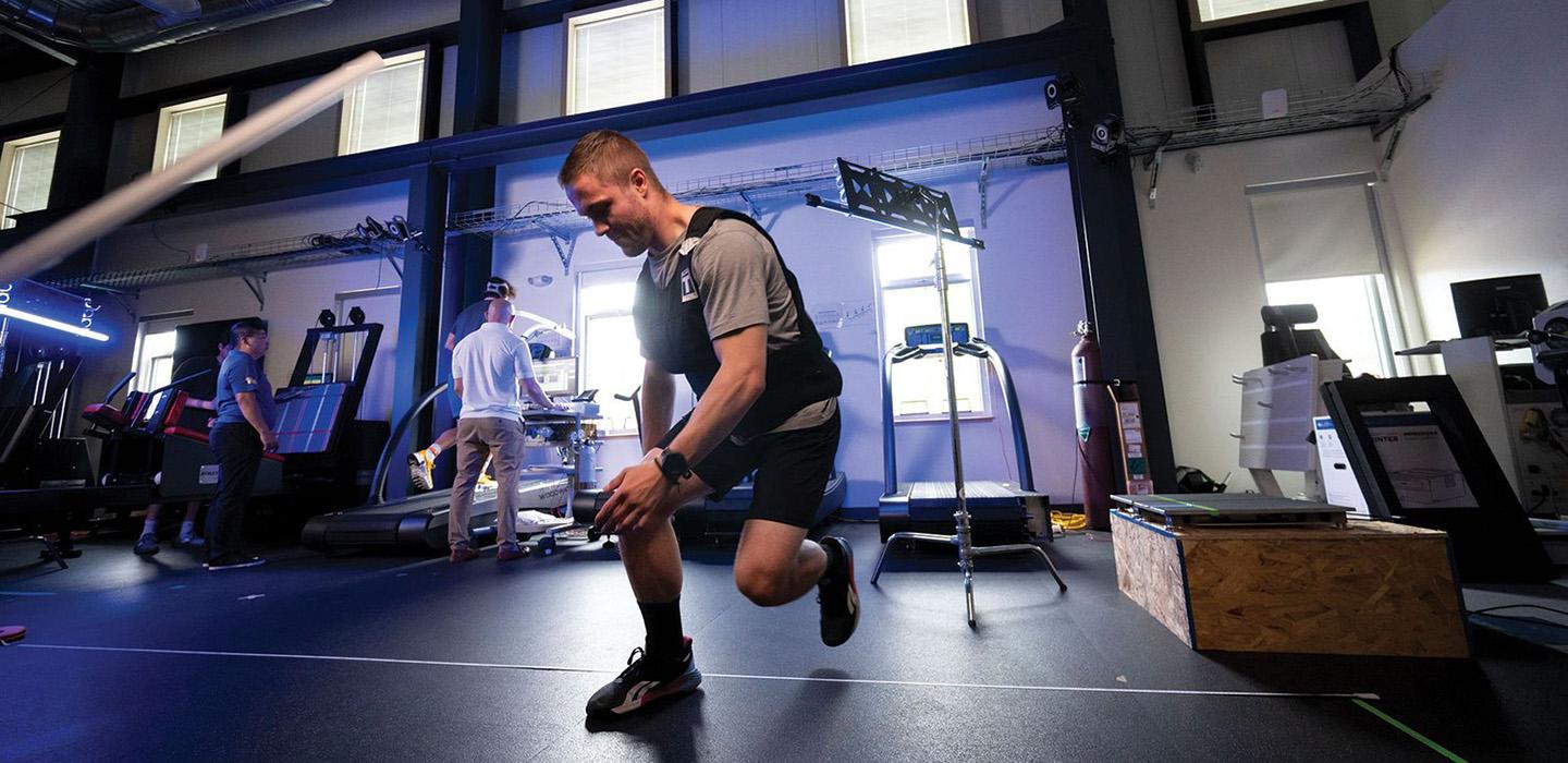 A person in athletic clothing exercising in a research lab