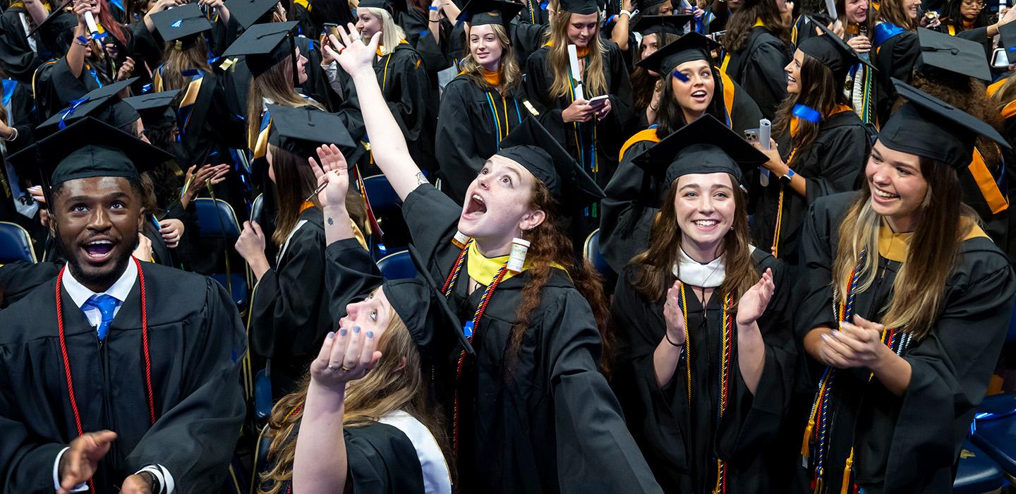Graduates clap and cheer after the commencement ceremony.