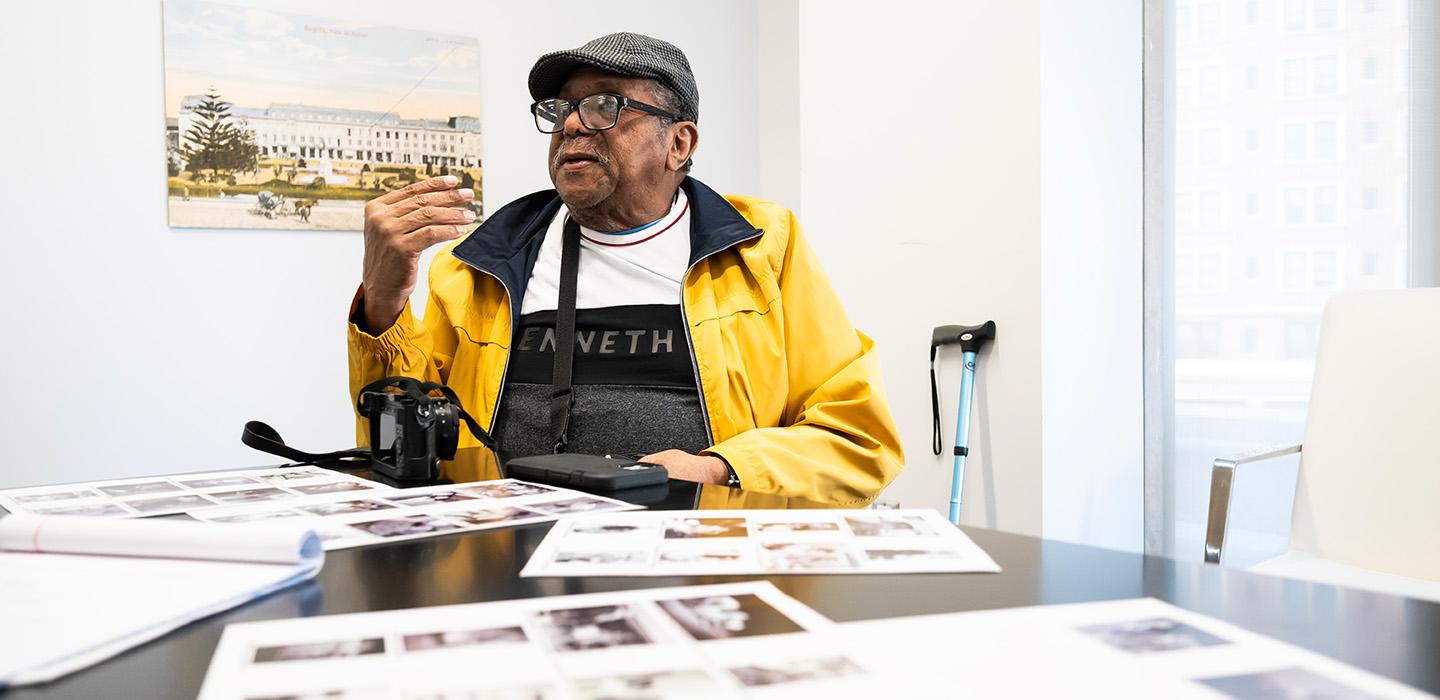 Hightower sits at a table, with pages of his photographs before him.