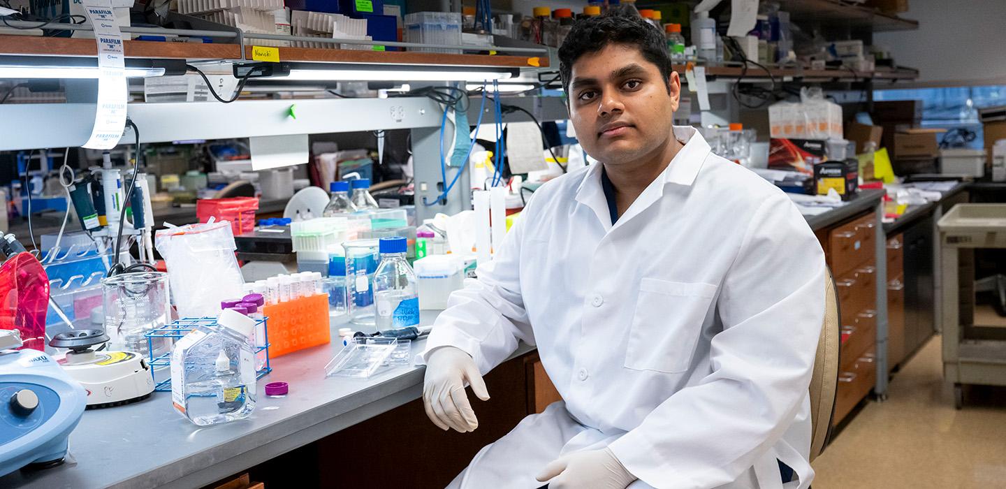 Rohit Mantena sits at a lab bench