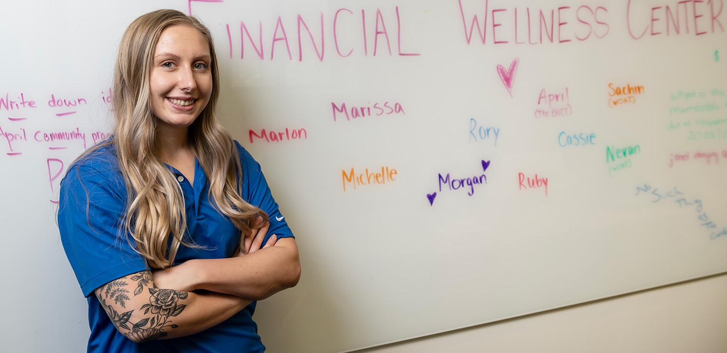 Michelle Kingsley in front of a whiteboard reading "Financial Wellness Center"
