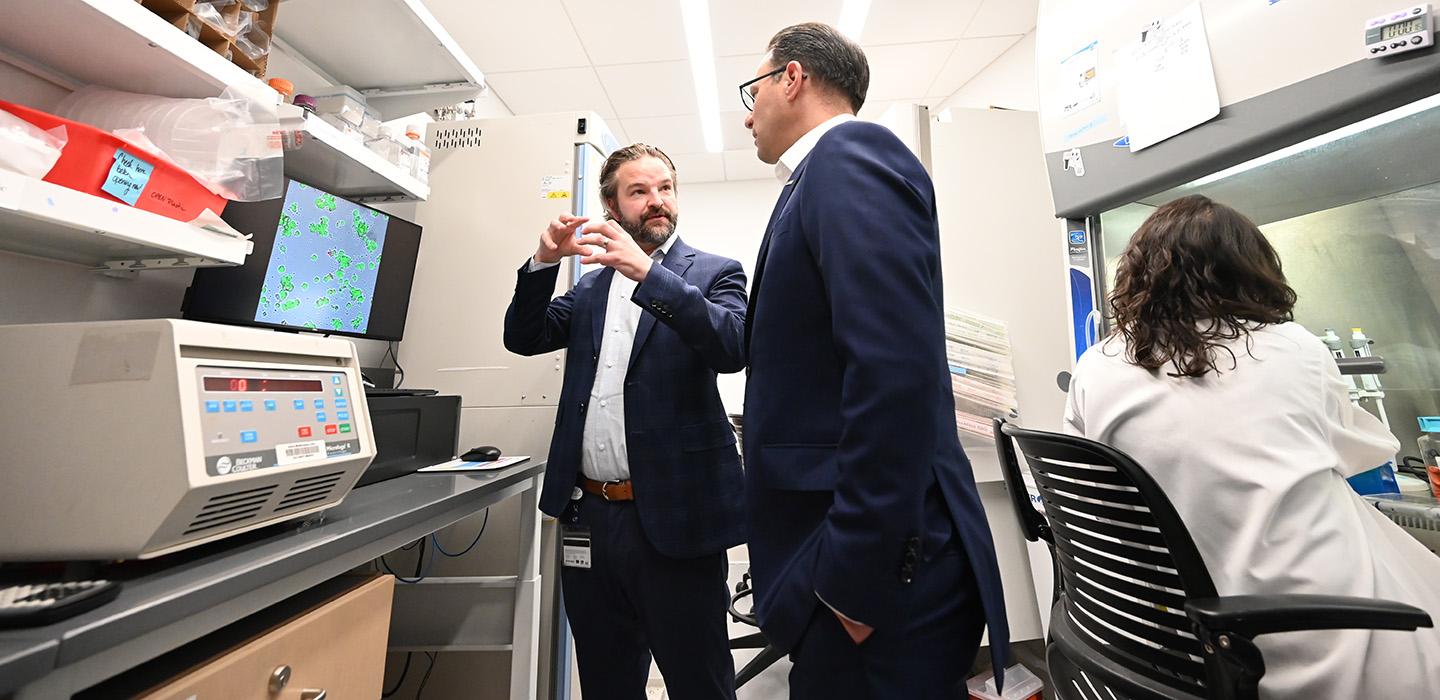 Gov. Shapiro talks to a researcher in a lab.