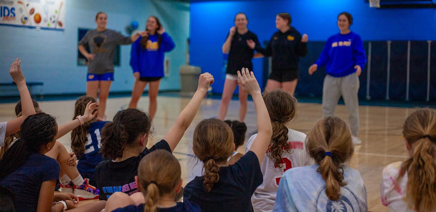 Lacrosse team in front of a crowd of children