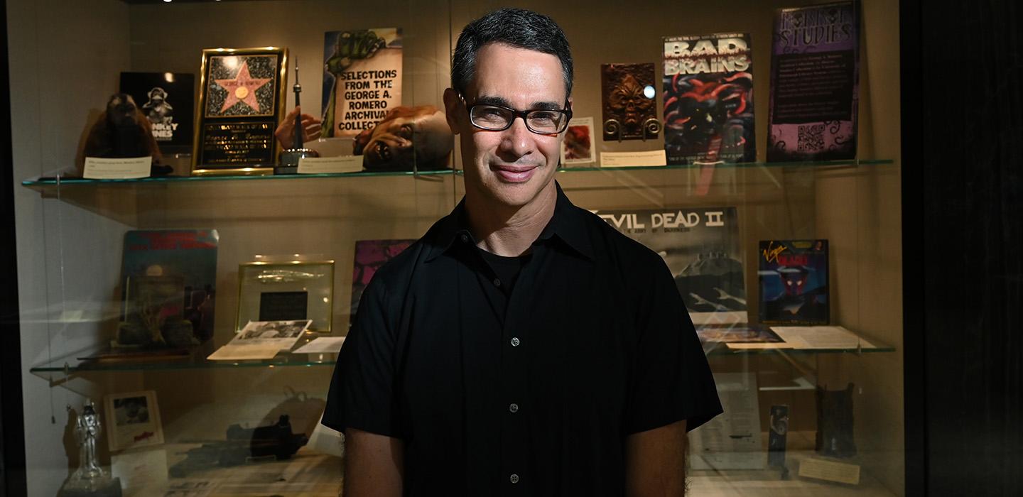 Adam Lowenstein in front of a display showcasing horror films