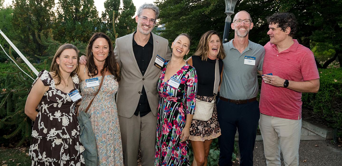 Alumni standing together and happily posing for a photo