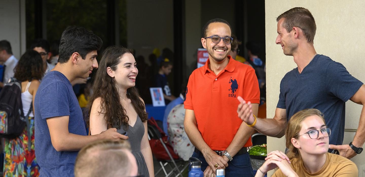 Two students standing next to one another before the pandemic