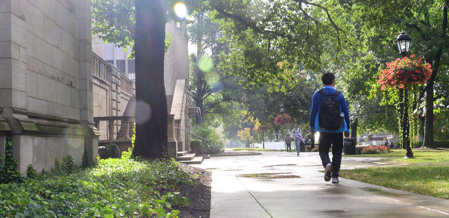 a person in blue walking near the Cathedral after a rain shower