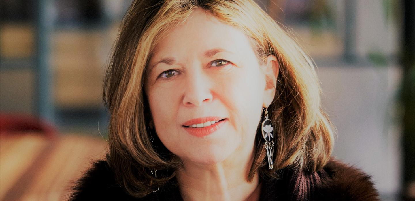 A woman in a brown coat and turquoise necklace