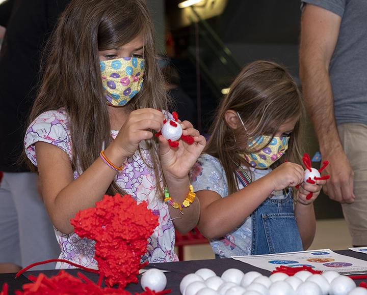 Children with face masks building COVID-19 virus models