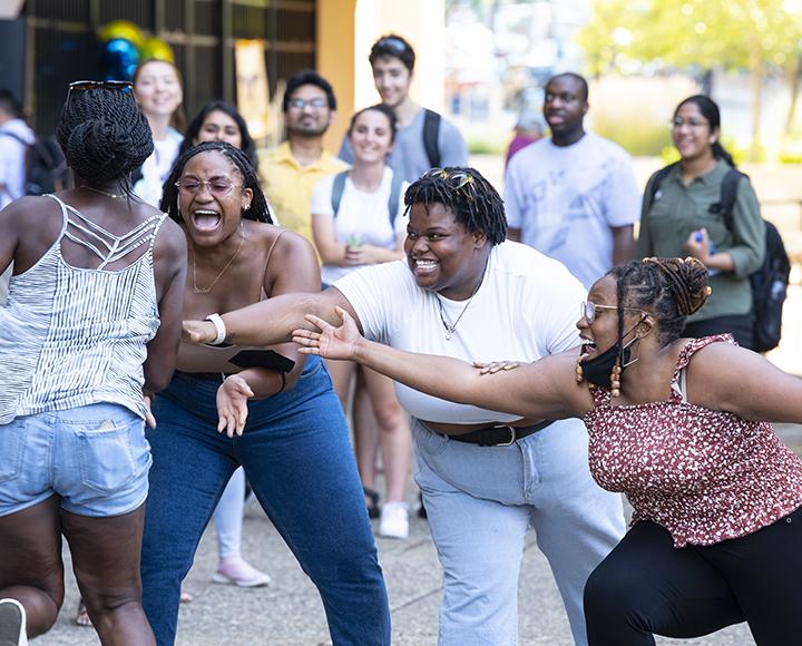 Ogechi Irondi, left, races to the finish line as teammates Carillon Young, Mikyle Johnson and Chandler Dangerfield reach out to encourage her home