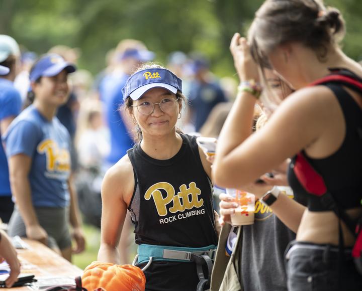Student smiling outside with Pitt Rock Climbing shirt