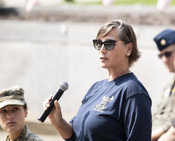 a woman in a blue shirt holding a microphone
