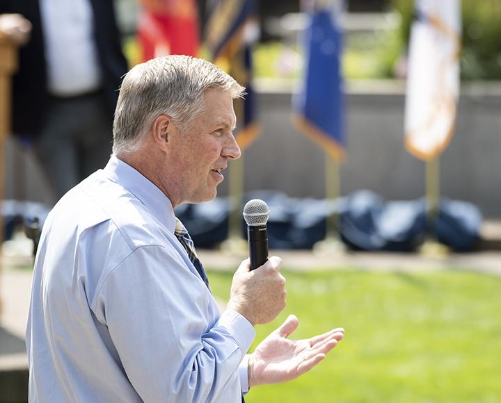 Gallgher in a blue shirt holding a mic