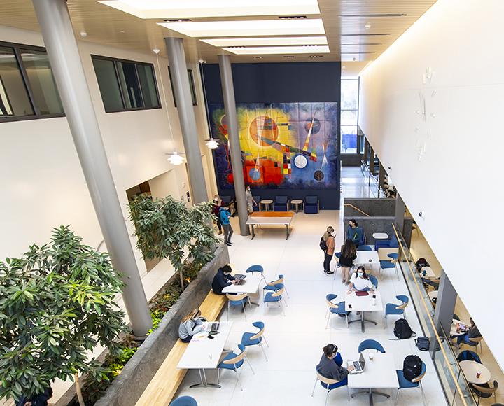 Large room with tables and chairs, and colorful artwork