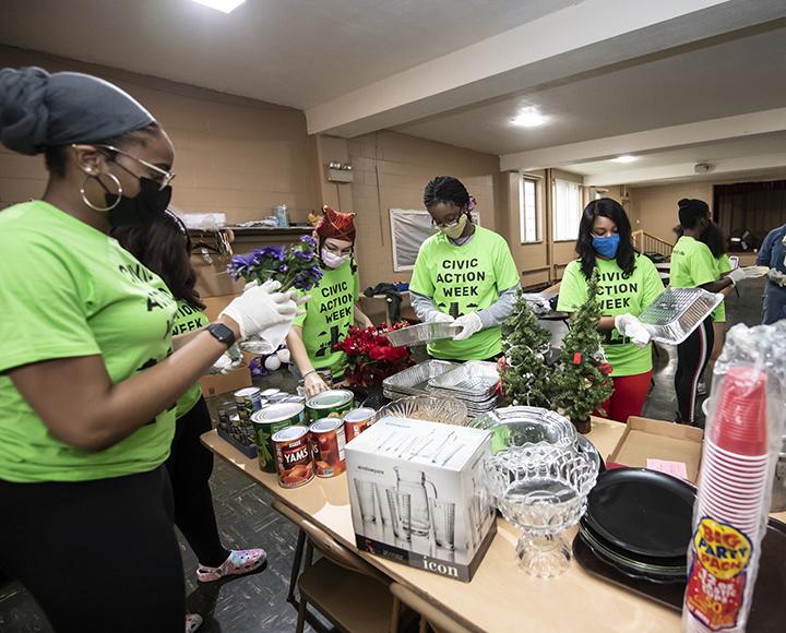 Volunteers with masks gathered around table with plants
