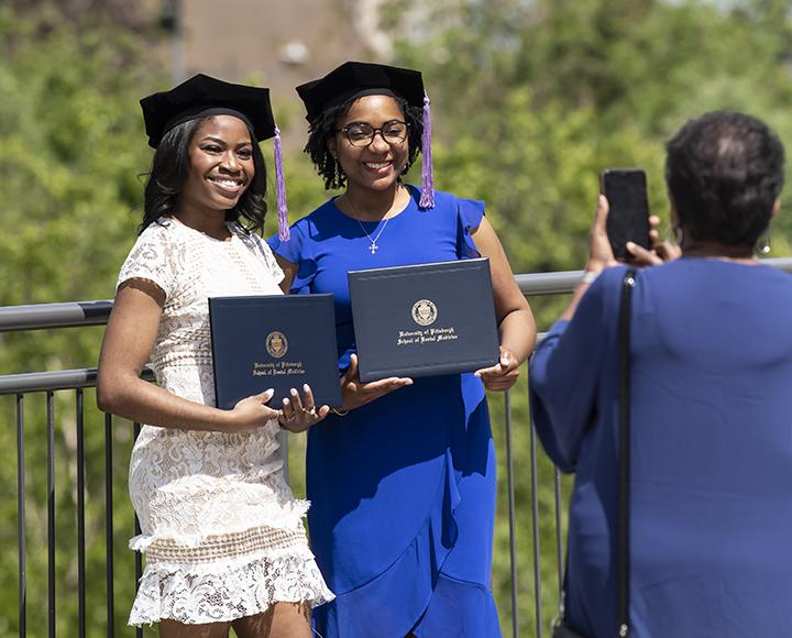 Toyin Ajayi and Kendra Rowey proudly holding their diplomas for photo