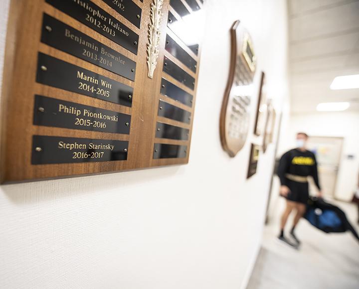 Matthew Starinsky walking past a plaque with Stephen Starinsky's name on it